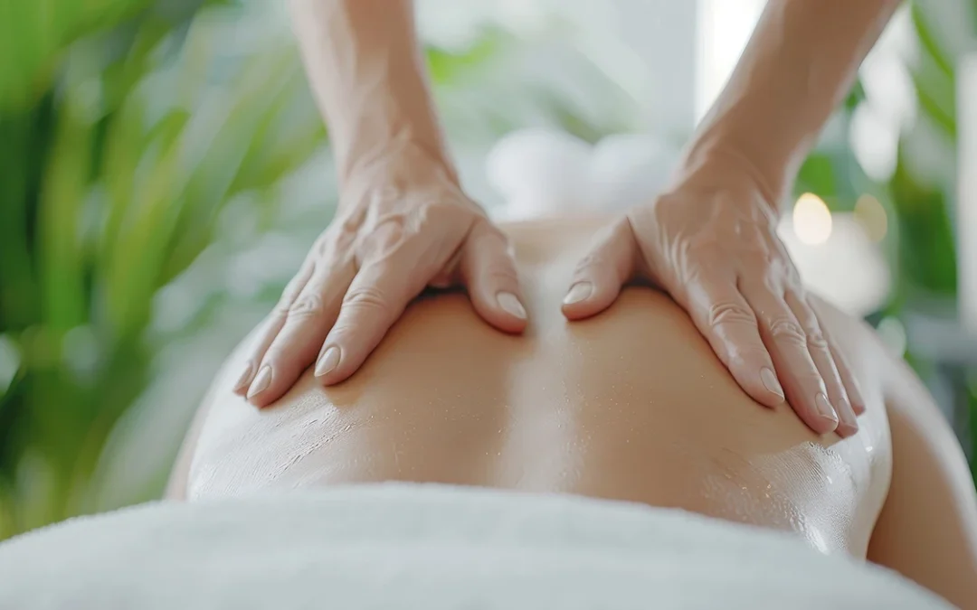 Person laying on table with massage therapist massaging their back.