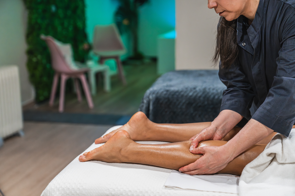 Massage Therapist performing trigger point therapy on a patient's legs.